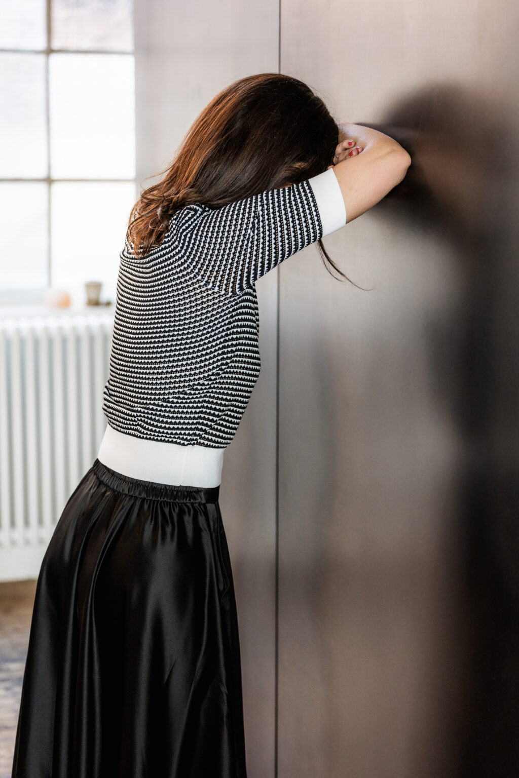 Frau mit Kopf an einer Wand